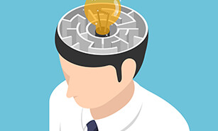 Lightbulb of ideas in the center of maze making up the inside of businessman's head 